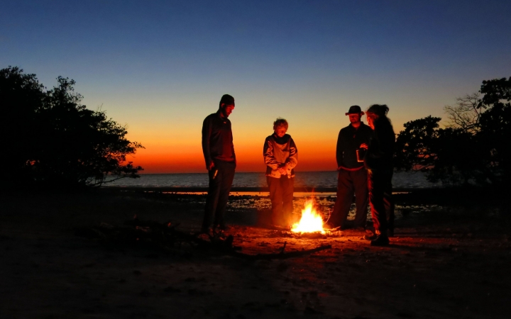 a group of veterans stand around a fire on an outward bound veterans expedition 